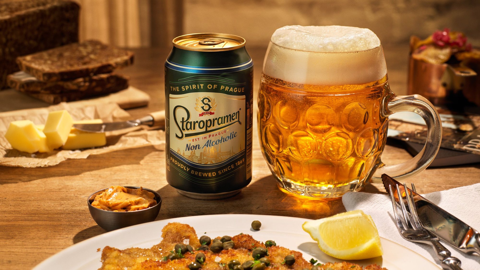 Staropramen can and beer mug behind a plate of schnitzel